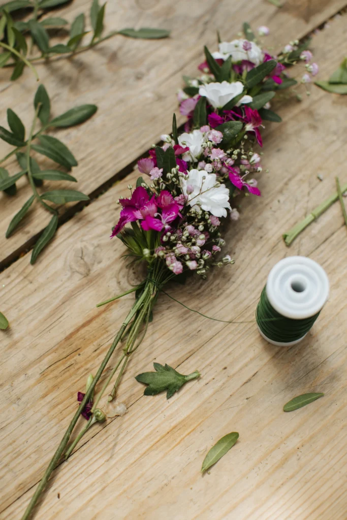 Bild pÄ blommor lÀngst en stomme av stÄltrÄd pÄ ett trÀbord.